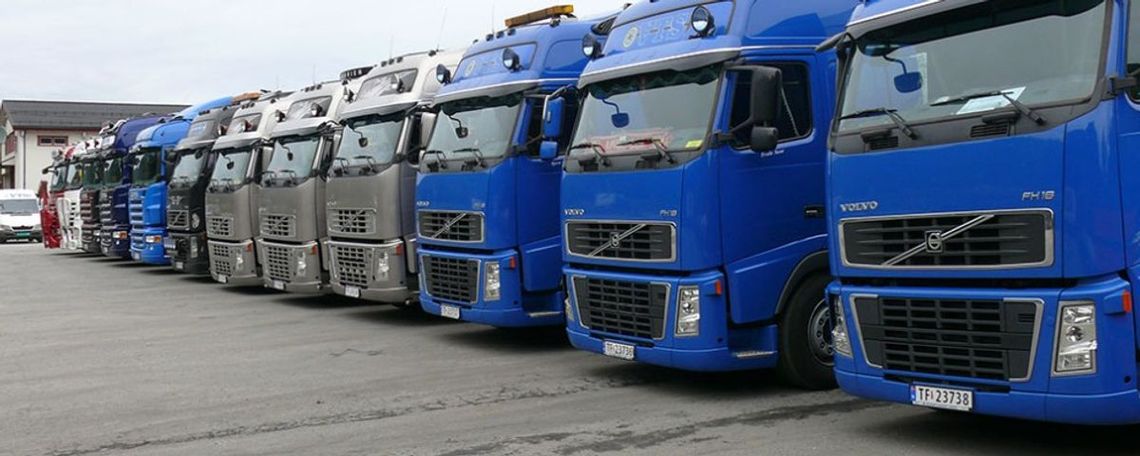 Trailere fra Voss Transportservice står parkert på rekke på parkeringsplass